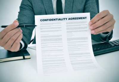 a young man showing a confidentiality agreement document